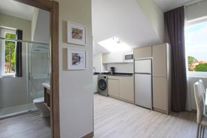 a kitchen with a refrigerator and a sink at Apartamentos Turísticos La Pontificia in Comillas