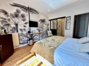1 dormitorio con 1 cama con un mural de palmeras en Chambre Roméo ou Juliette, en Honfleur