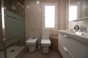 Un baño con inodoro, lavabo y ducha. en Malasaña House, en Málaga
