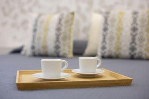 dos tazas de café sentadas en una bandeja de madera en Malasaña House, en Málaga 8 fotos más