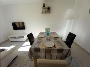 a wooden table in a living room with a couch at Appart T3 avec Cours et Parking Privé in Montélimar