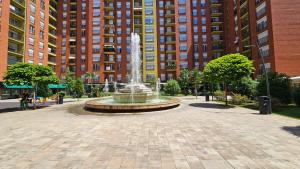 a fountain in the middle of a courtyard with tall buildings at Superb 1 bedroom in the best zone of the city. in Ferizaj