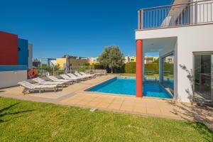 a swimming pool with lounge chairs next to a house at Capetown Marina Luxury Villa - Private Pool in Albufeira