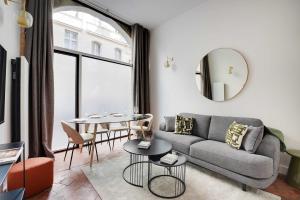 una sala de estar con un sofá y una mesa en Magnifique appt avec 2 salons- 1BD-6P - Notre-Dame, en París