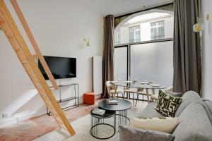 una sala de estar con un sofá y una mesa en Magnifique appt avec 2 salons- 1BD-6P - Notre-Dame, en París