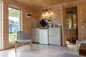 a kitchen with wooden walls and a white refrigerator at 2bedroom house in Mērsrags