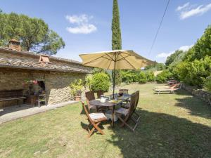 a table and chairs with an umbrella in a yard at Holiday Home Il Lamone by Interhome in Ambra