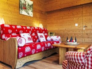 uma sala de estar com um sofá vermelho e uma mesa em Chalet Mirabeau 8 by Interhome em Nendaz