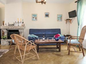 ein Wohnzimmer mit einem blauen Sofa und einem Tisch in der Unterkunft Holiday Home Les Hortensias by Interhome in Kermaria-Sulard