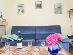 eine blaue Couch mit einem Tisch und einer Flasche Wein in der Unterkunft Holiday Home Les Hortensias by Interhome in Kermaria-Sulard
