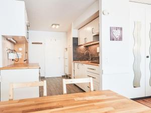 a kitchen with white cabinets and a wooden table at Studio Greppon 107 by Interhome in Les Collons