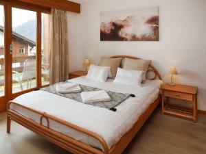 a bedroom with a bed and a large window at Apartment Lichen 4 by Interhome in Verbier