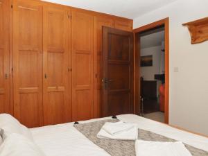 a bedroom with wooden cabinets and a bed with white sheets at Apartment Lichen 4 by Interhome in Verbier