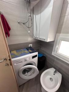 Un pequeño baño con lavadora y WC. en Casa vacanze, en Radhimë