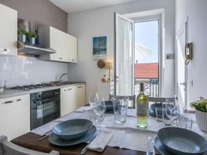 a kitchen with a table with plates and wine glasses at Apartment Maestrale by Interhome in Marina di Cecina