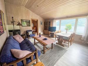 un soggiorno con un divano blu e un tavolo di Holiday Home Nausthammar by Interhome a Davik