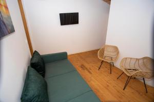 a living room with a green couch and two chairs at Calme Beach in Vlorë