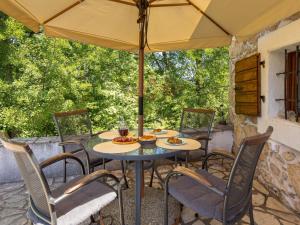Una mesa y sillas bajo una sombrilla en un patio. en Apartment Mia by Interhome, en Dobrinj