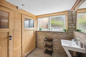 a bathroom with a white sink and windows at Antico Mulino Pension Todtmoos in Todtmoos