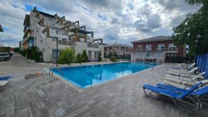 a swimming pool with lounge chairs next to a building at Airport Bea in Otopeni