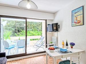 Una sala de estar con una mesa y sillas blancas. en Apartment La Pomme de Pin by Interhome, en La Baule-les-Pins