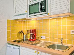 una cocina con fregadero y microondas en Apartment La Pomme de Pin by Interhome, en La Baule-les-Pins