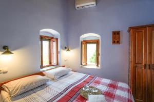 a blue bedroom with a bed and two windows at Symi Uptown Indigo in Symi