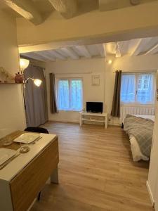 a large room with a bed and a desk and a table at Studio Cosy Beauvoisine in Rouen +1 photo