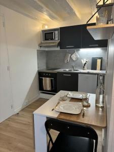 a small kitchen with a table and a microwave at Studio Cosy Beauvoisine in Rouen