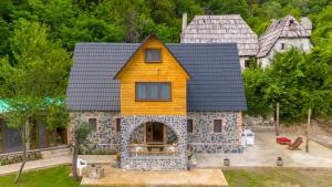 una casa amarilla encima de un edificio de piedra en villa prelatheth, en Theth