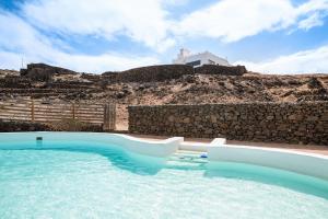 a pool with a water slide in front of a hill at Playa Marina Eco Beach Villa in Arrieta