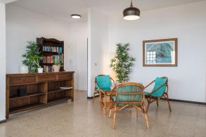 a room with a table and chairs and a book shelf at Playa Marina Eco Beach Villa in Arrieta