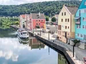 a boat is docked in a river next to buildings at Holiday Home Tiny Haus Auszeit by Interhome in Riedenburg