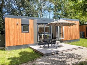 a house with a table and chairs and an umbrella at Holiday Home Tiny Haus Auszeit by Interhome in Riedenburg
