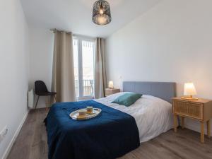 ein Schlafzimmer mit einem Bett mit einer blauen Decke in der Unterkunft Apartment Cap Océan-11 by Interhome in Capbreton