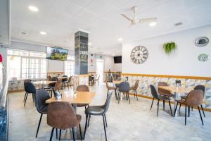 a restaurant with tables and chairs and a clock on the wall at Hotel La Terraza in Sanxenxo