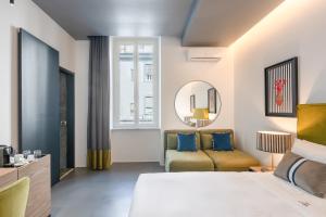 那不勒斯Le Mummarelle的卧室里有一张床、一张沙发和一面镜子