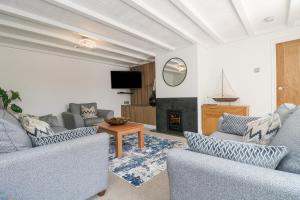 a living room with two couches and a fireplace at Scrumpy in Helston