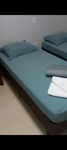 two beds in a room with blue sheets and pillows at Casa montserrat in Nova Mutum
