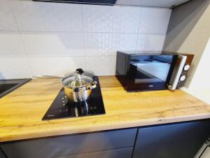 a pot on a stove next to a microwave at Бухар Жирау 44 in Karagandy