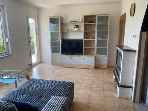 Una sala de estar con un sofá y un televisor en Apartma Bossamarino, en Koper
