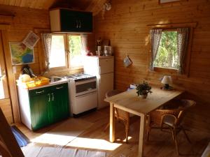 a kitchen with a table in a wooden cabin at Gîtes à la Ferme - Hautes-Corbières in Termes