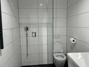 y baño con ducha, aseo y teléfono. en Emma, en Bar