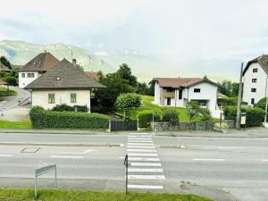an empty street with houses and a crosswalk at Le Golden Lake-5min du LAC à pied-Parking privé gratuit in Sévrier