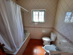 un bagno con un water, una vasca e un lavandino di Vicentina Rooms & Apartments - Duna Parque Resorts & Hotels a Vila Nova de Milfontes