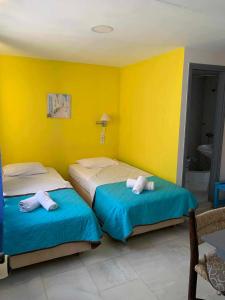 two beds in a room with yellow walls at Sissi Mare Apartments in Sissi +31 photos