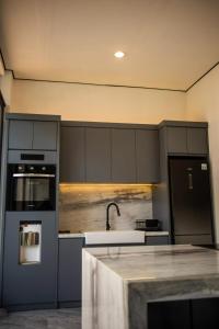 a kitchen with gray cabinets and a sink and a refrigerator at LeRoca Villa in Bandung +45 photos