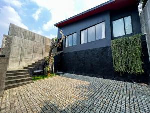 a building with a staircase next to a brick courtyard at LeRoca Villa in Bandung
