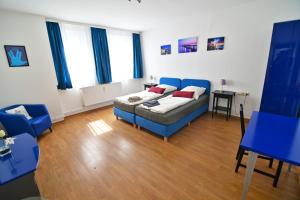 a living room with a bed and a blue couch at Am Schloss 108 in Schwerin
