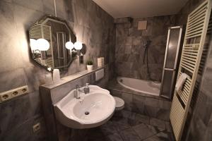 a bathroom with a sink and a mirror and a tub at Am Schloss 108 in Schwerin